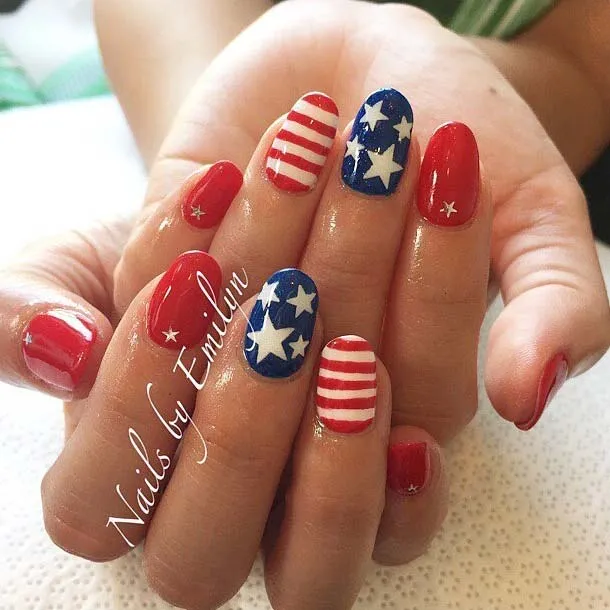 Red nails with a patriotic twist featuring white and blue accents like stars and stripes, perfect for a chic and sophisticated 4th of July look